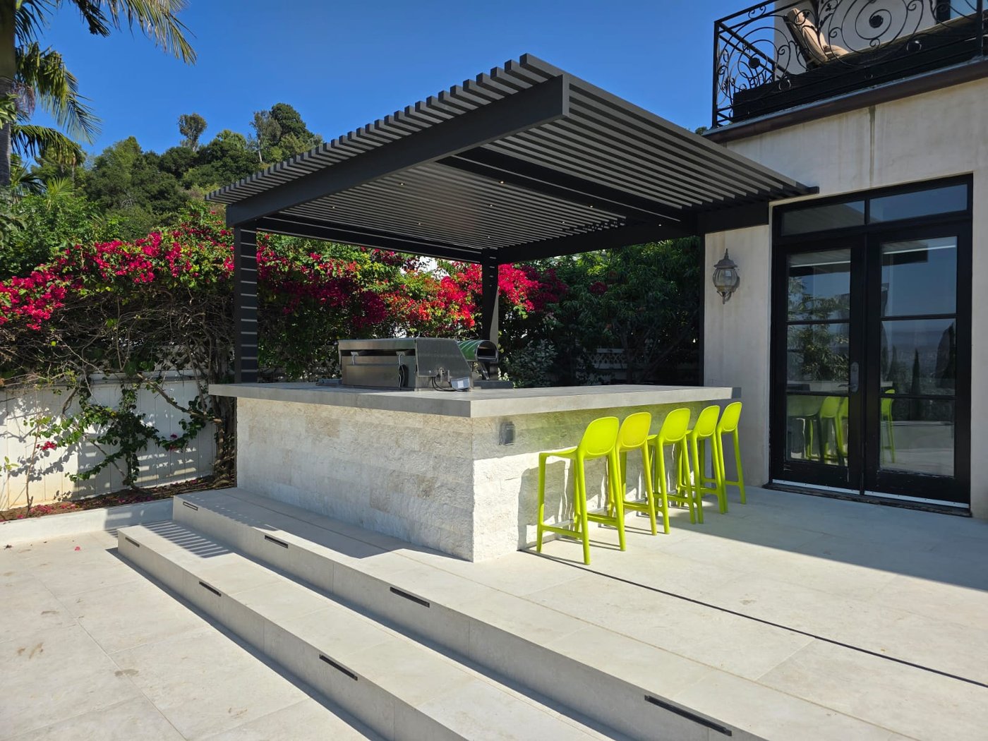 4K louvered cover over a hillside outdoor kitchen