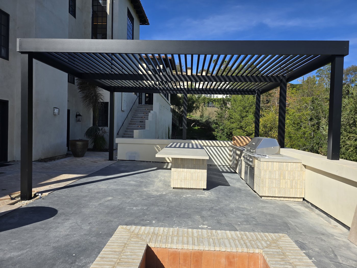 4K louvered cover over a hillside outdoor kitchen