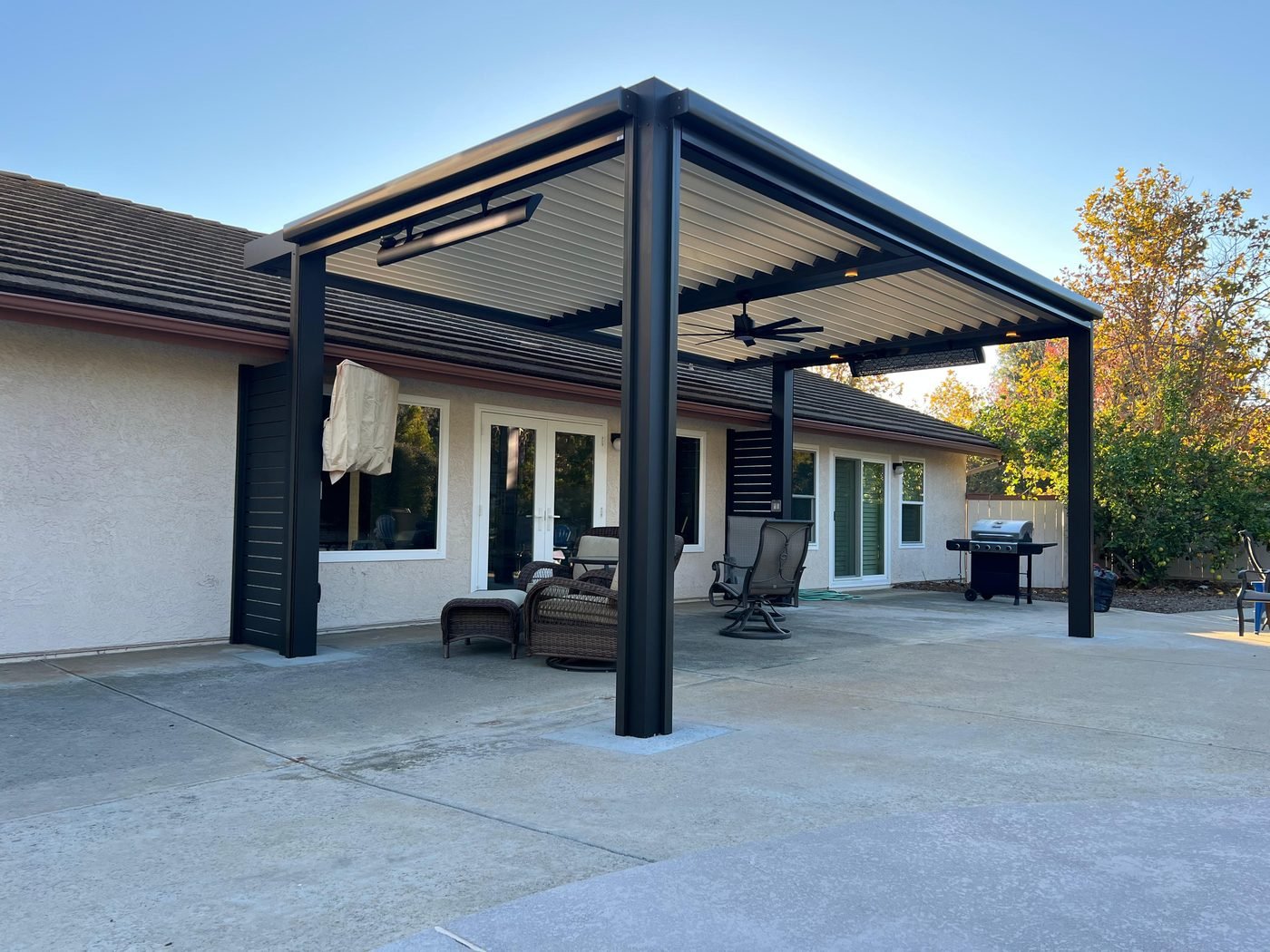 Four Seasons louvered roof over a firepit and planter, modern backyard