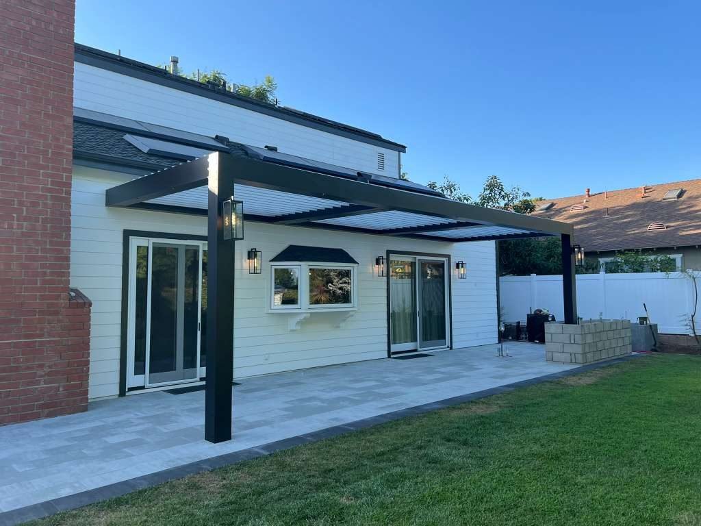 Black Four Seasons louvered roof over an outdoor kitchen, hillside home