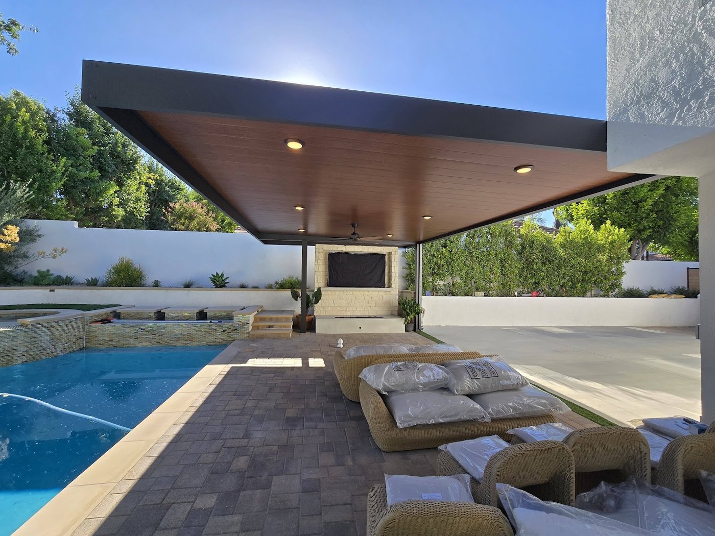 Insulated cover with wood-grain underside beside a pool