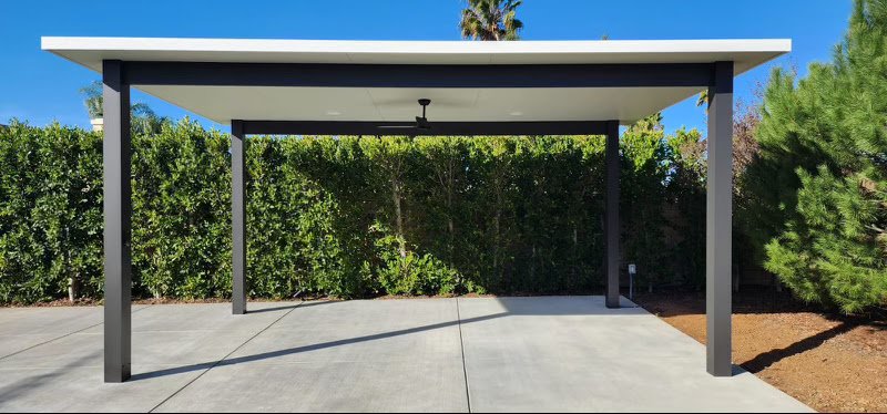 Freestanding insulated cover with ceiling fan and hedge backdrop
