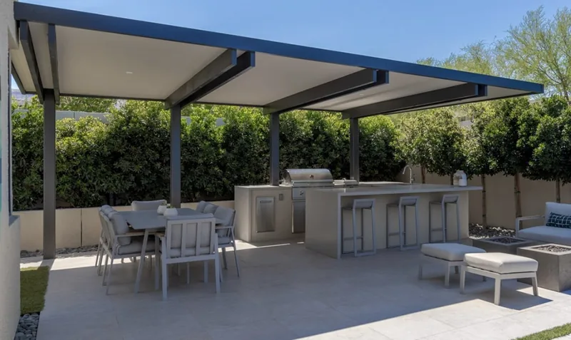 Extra-large semi-traditional 4K cantilever with white 3-inch insulated cover and one-foot overhangs, over a barbecue and seating area