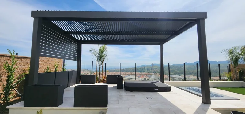 Freestanding 4K frame with Solara adjustable louvers in dark brown and a 1x4 4K louvered privacy wall, overlooking a valley