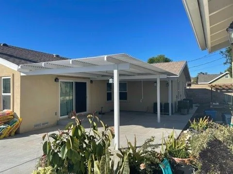 White Solara adjustable louvered cover attached to the house, roll-form blades with manual opening on Solara posts and beam