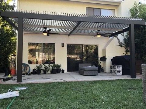 Motorized Solara adjustable louvered cover in Adobe with two ceiling fans, on an espresso 4K frame and posts